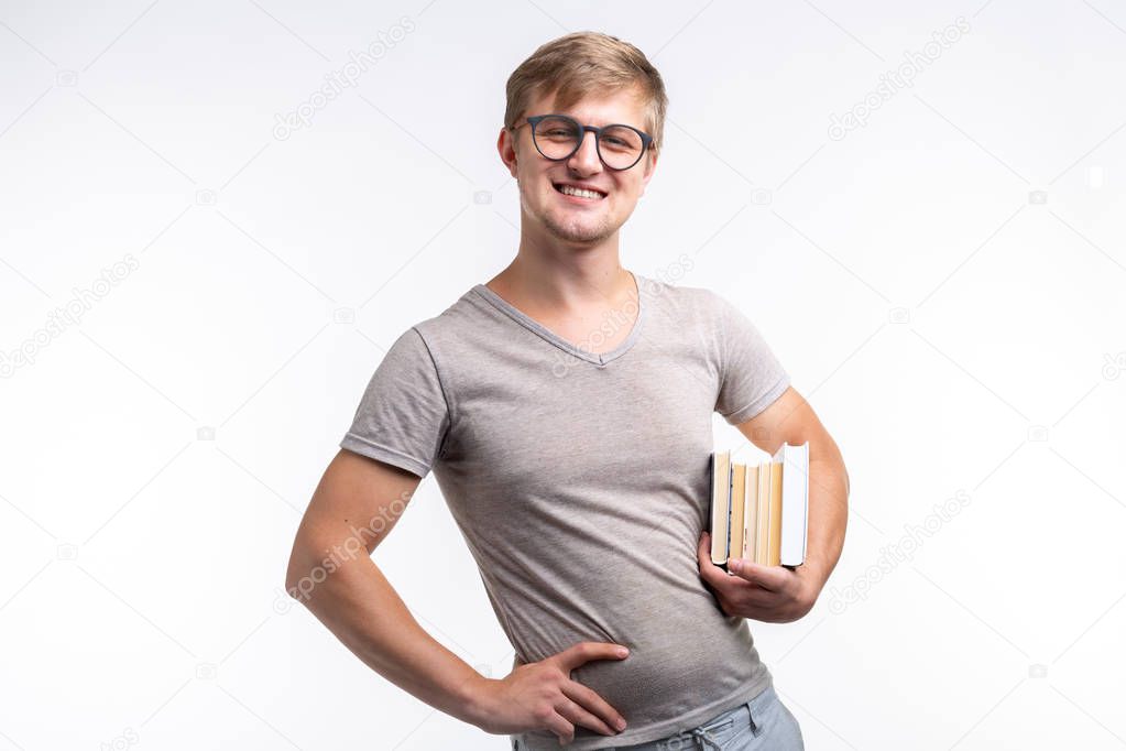 Reading, education, people concept - a young student man holding many books