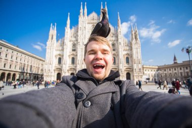 Seyahat, tatil ve kış tatil kavramı - mutlu adamı kabul selfie fotoğraf komik güvercinler ile Duomo Milan Katedrali önünde