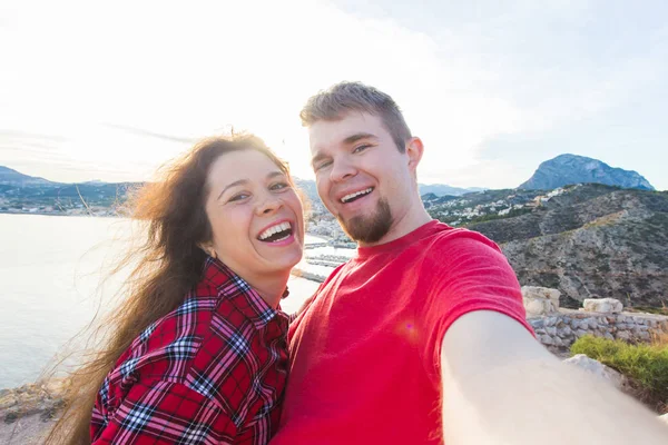 Cestování, dovolená a dovolená koncepce - mladý pár pořizování selfie společně na seacoast — Stock fotografie