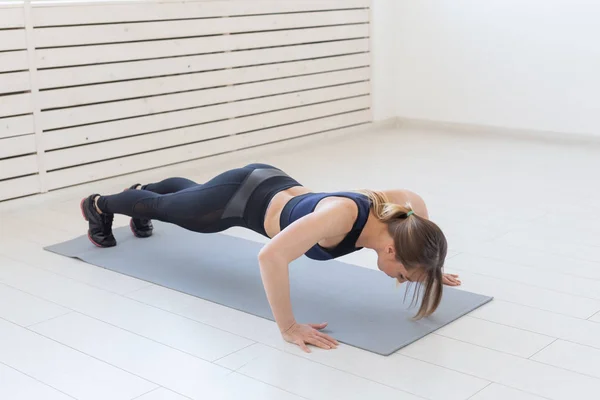 Gente, deporte y fitness concepto - joven deportista hermosa haciendo flexiones —  Fotos de Stock