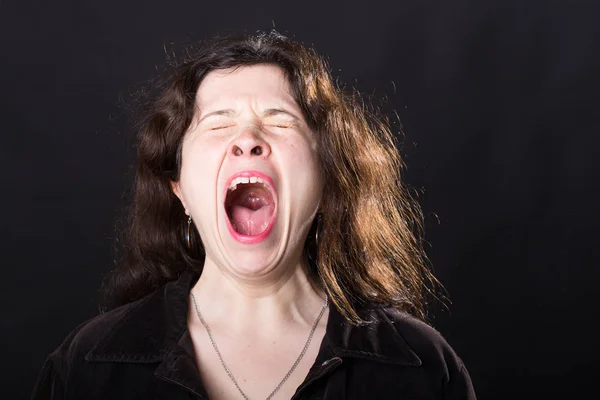 Concepto de emociones negativas - Mujer joven gritando asustada de pie sobre fondo negro . — Foto de Stock