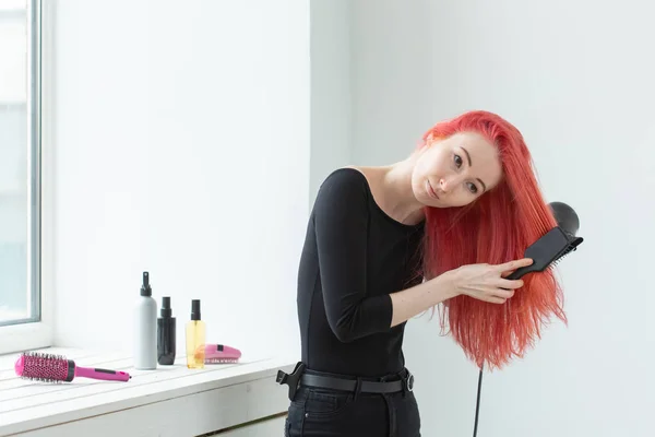 Hairdresser, style, people concept - woman id blowing dry her colored hair — Stock Photo, Image