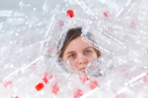 Umweltschutz, Menschen und recyclingfähiges Kunststoffkonzept - erschöpfte Frau, die über Umweltkatastrophe besorgt ist, sitzt in einem Stapel Plastikflaschen — Stockfoto