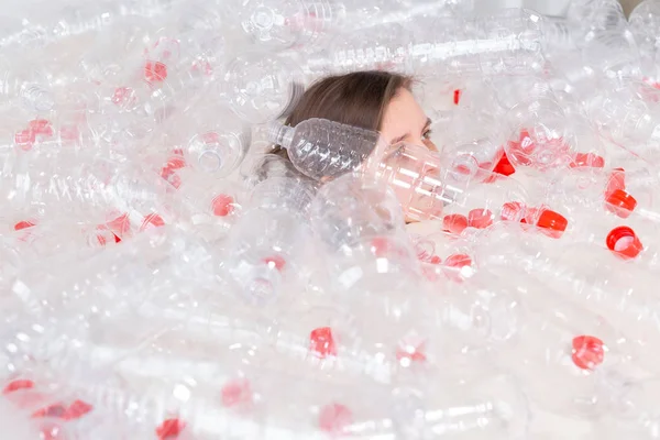 La mujer enferma deshidratada está acostada en un montón de botellas de plástico. Problema de contaminación ambiental. Detener naturaleza basura concepto de protección del medio ambiente — Foto de Stock