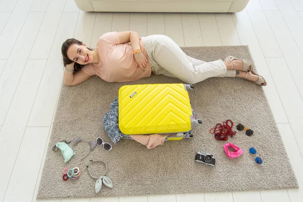 Vacanze, viaggio e concetto di persone - Giovane bella donna raccoglie una valigia in un viaggio estivo, vista dall'alto — Foto Stock