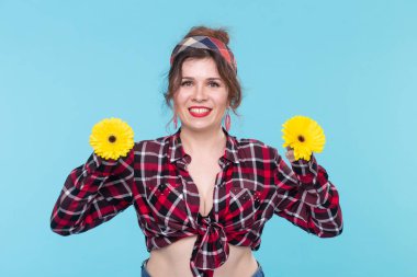 Yaz, pin-up ve eğlenceli kavram - mavi arka plan üzerinde gerberas ile güzel kadın