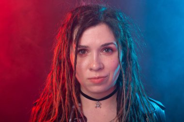 Gençlik, saç modeli ve modern kavramı-dreadlocks ile genç kadın kırmızı ve mavi ışık arka plan üzerinde gülümsüyor