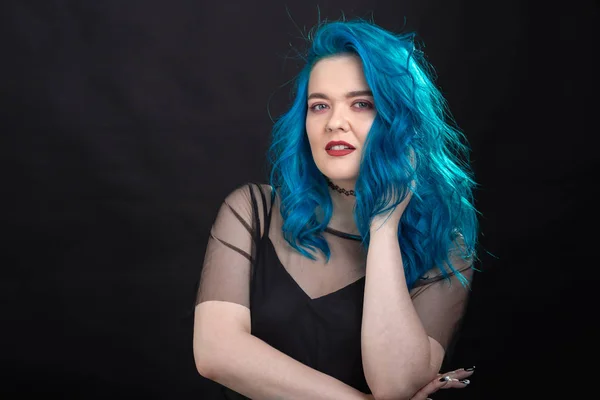 Estilo, moda e conceito de cabelo - close-up retrato de jovem mulher em vestido preto com cabelo azul no fundo preto — Fotografia de Stock