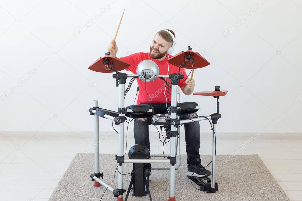 People, free time and hobby concept - bearded man drummer playing the drum.