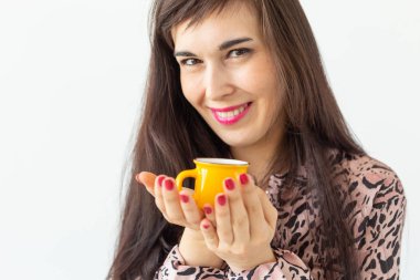 Elinde beyaz bir arka plan üzerinde poz küçük bir sarı kupa tutan oyuncu genç esmer kadın