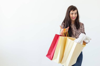 Büyüleyici genç neşeli esmer kadın kopya alanı ile beyaz bir arka plan üzerinde poz yeni bir giyim ile elinde çanta tutar