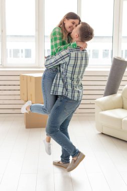 Yeni evlerine taşınırken sevinç kucaklayan genç çift Loving. Genç ailenin hareketli ve ev ısınması kavramı.