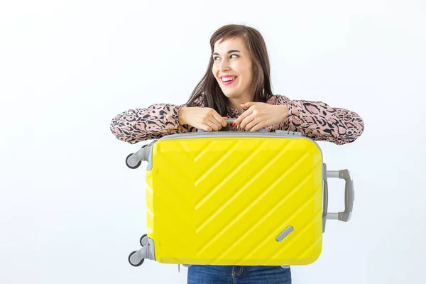 Joven morena sonriente alegre posando con una maleta amarilla mientras espera unas vacaciones. El concepto de turismo y viajes — Foto de Stock