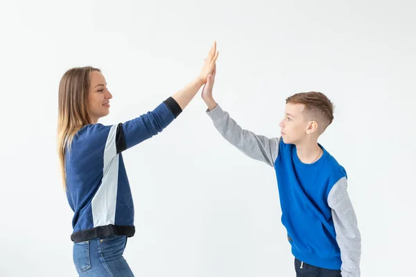 Γοητευτική μητέρα και γιος χειροκροτούν ο ένας τον άλλο, απολαμβάνοντας μια τέλεια κίνηση σε ένα νέο διαμέρισμα. Η έννοια της μετακίνησης μιας νεαρής οικογένειας. — Φωτογραφία Αρχείου