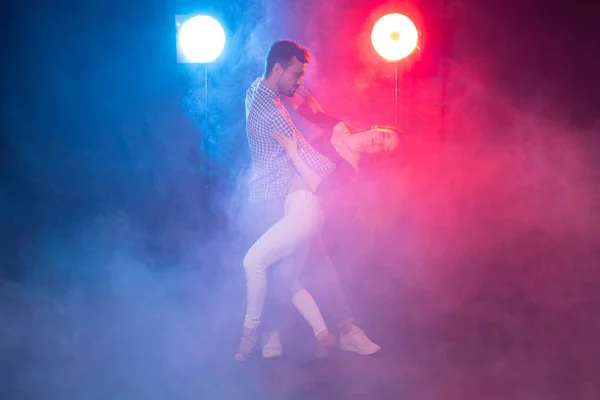 Social dance, bachata, kizomba, zouk and tango concept - Man hugs woman while dancing over lights — Stock Photo, Image