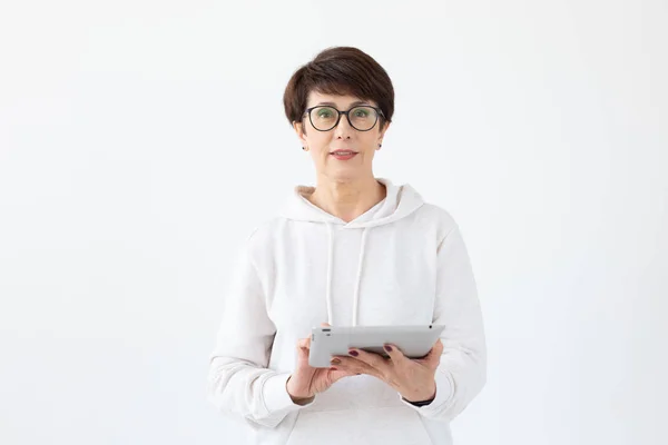 Технології та концепція сучасних людей - Красива жінка 50 років з коротким волоссям, що тримає планшет на білому тлі — стокове фото