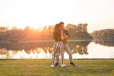 Romantik, sosyal dans, insanlar kavramı - genç çift bachata güneşli bir günde göl kenarında dans