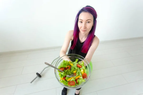Vue du dessus d'une jeune fille hipster asiatique qui mange une salade de légumes légers après une séance d'entraînement chez elle. Concept de perte de poids et mode de vie sain . — Photo