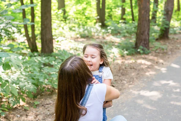 Familia, naturaleza, concepto de personas - madre e hija abrazándose en el parque —  Fotos de Stock