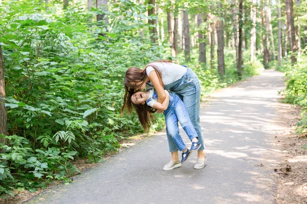 Natureza, família, conceito de pessoas - Conceito de família e natureza - Mãe bonita beija sua filhinha na bochecha — Fotografia de Stock