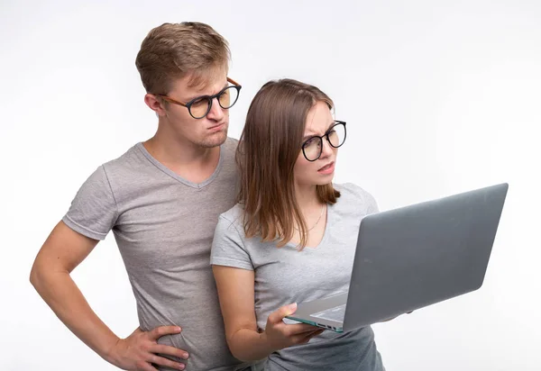 Nerds, Studium, People-Konzept - ein paar Studenten sehen mit Laptop aus, als würden sie über etwas nachdenken — Stockfoto