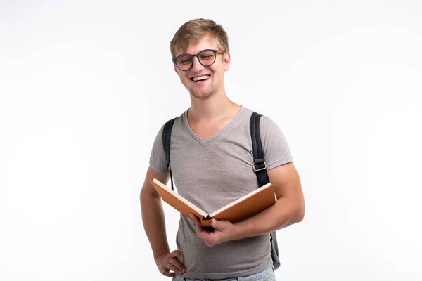 Educación, universidad, concepto de personas: un estudiante masculino con gafas abrió un libro y sonrió sobre un fondo blanco — Foto de Stock