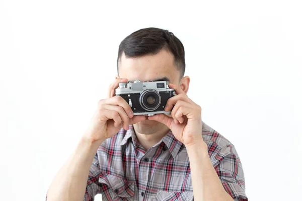 Mensen hobby en Leisure concept-jonge Aziatische man met behulp van zijn vintage camera op witte achtergrond — Stockfoto