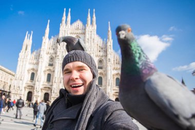 Kış seyahat, tatil ve kuşlar kavramı - selfie güvercinler yakınındaki Milan Katedrali Duomo di Milano, İtalya ile alarak genç komik adam.