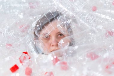 Susuz kalmış hasta kadın plastik şişeyığının içinde yatıyor. Çevre kirliliği sorunu. Doğaçöp çevre koruma konsepti durdurun
