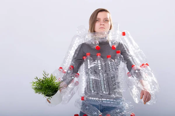 Mujer enferma deshidratada está de pie con vestido en botellas de plástico que sostienen la planta verde. Problema de contaminación ambiental. Detener naturaleza basura concepto de protección del medio ambiente — Foto de Stock