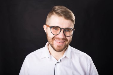 Siyah arka plan üzerinde izole kamera bakarak gülümseyen sakallı yakışıklı adam Portresi