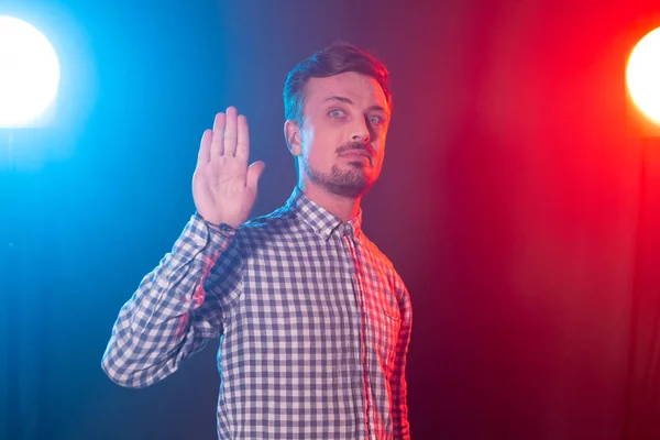 Homem hipster bonito barbudo jovem sério mostra palma para cima retratando parar em fundo azul-vermelho. Conceito de rejeição . — Fotografia de Stock