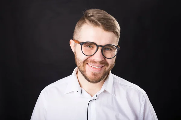 Retrato de hombre guapo barbudo sonriente mirando la cámara aislada sobre fondo negro — Foto de Stock