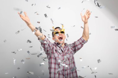 İnsanlar, tatil ve parti kavramı - komik surat konfeti ile ekose gömlekli adam