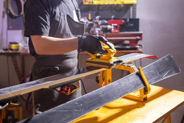 Close-up van de jonge man repareren van de ski in de service — Stockfoto