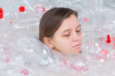 Plastik kirlilik sorunu ve çevre koruma. Plastik şişe yığını içinde zayıf yorgun kadın. Earth konsepti kaydedin. Doğanın temizliği.