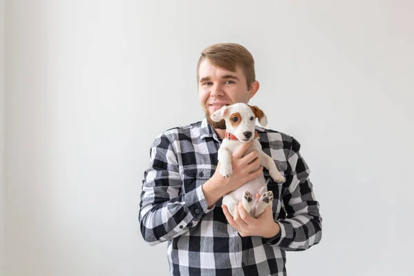 人、ペット、犬のコンセプト - ホワイト バック グラウンド保有子犬ジャック ラッセル テリアに笑みを浮かべて男 — ストック写真
