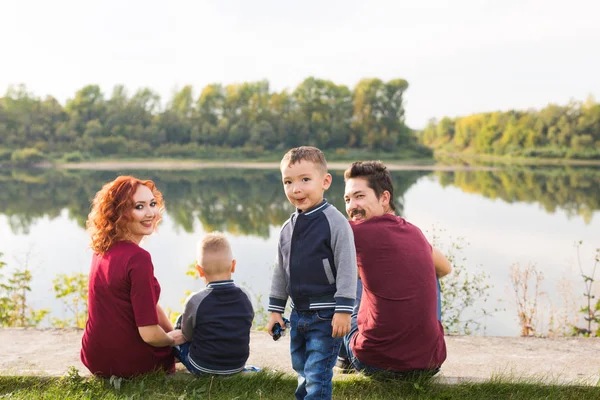 Los niños, la paternidad y el concepto de la naturaleza - Gran familia sentada en la hierba — Foto de Stock