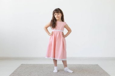 Küçük kız bir model, stüdyoda pembe bir elbise içinde
