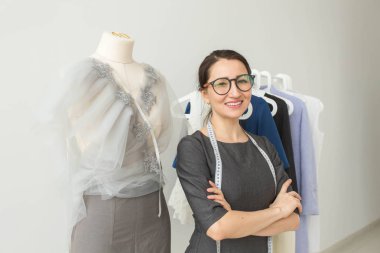 Terzi, moda tasarımcısı, terzi ve insanlar kavramı - güzel moda kadın Tasarımcısı stüdyoda ayakta