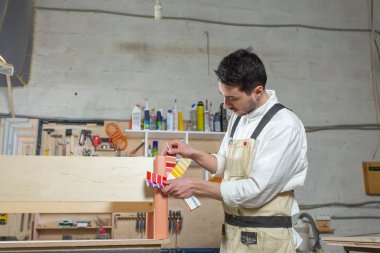 Mobilya fabrikasında çalışan genç sakallı adam, mobilya için renk eşleştirme