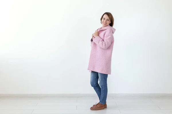Bájos fiatal női modell pózol egy fehér háttér tervező rózsaszín kabátot. A koncepció egy egyedi kézműves design. Reklámfelület, copyspace — Stock Fotó