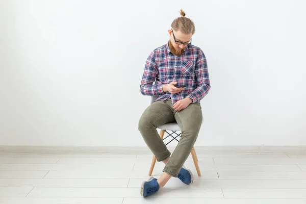 Mladý alternativců vousatý muž sedící na bílém pozadí s prostorem pro kopírování — Stock fotografie