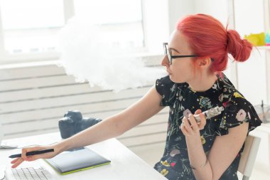 Yaratıcı, grafik tasarımcı, insan kavramı - genç yaratıcı kadın bir grafik tablet çalışırken bir vape sigara