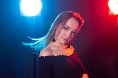 Gece kulübü, gece hayatı ve insan konsepti-karanlıkta poz veren genç kadın