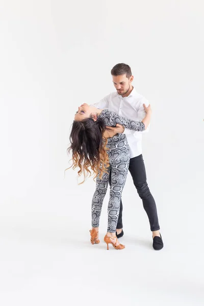 Dança social, bachata, kizomba, zouk, conceito de tango - Homem abraça mulher enquanto dança sobre fundo branco com espaço de cópia — Fotografia de Stock