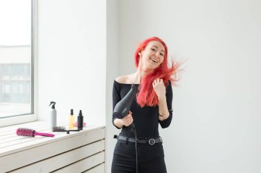 Kuaför, güzellik salonu ve insan kavramı - beyaz arka plan üzerinde saç kurutma makinesi ile genç kadın saç stilisti