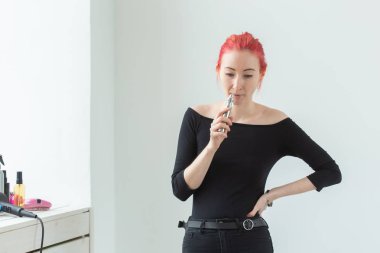 Gençlik ve bağımlılık kavramı - genç kızıl saçlı kadın pencere yakınında vape sigara