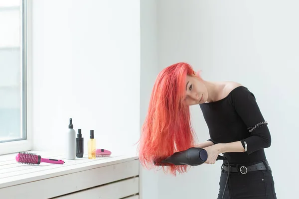 Парикмахер, стиль, люди концепции - женщина выдувает сухой ее цветные волосы — стоковое фото