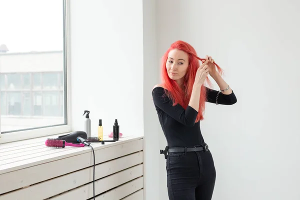 Schöne rothaarige Mädchen mit langen Haaren, sie ist webt einen Zopf, in einem Schönheitssalon. professionelle Haarpflege und Frisurengestaltung. — Stockfoto